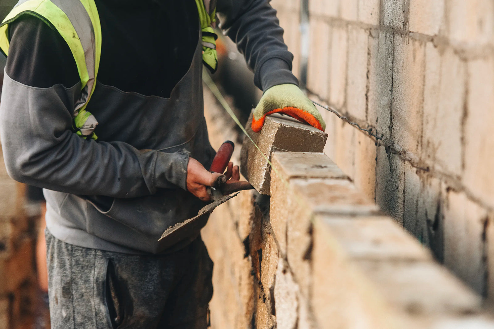Construction workers laying brickwork on building project